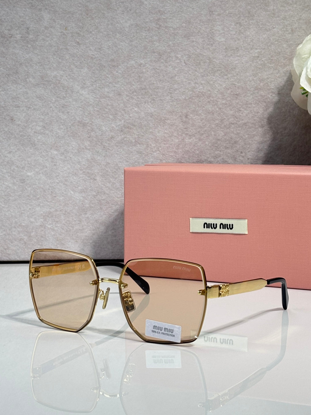 MiuMiu square gold glasses with light amber lenses and gold-tone bridge detail