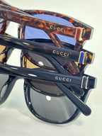 Gucci sunglasses close-up, tortoiseshell temple with gold-tone hinge and logo