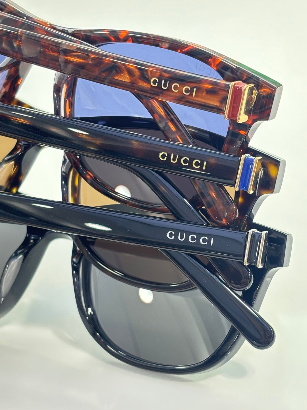 Gucci sunglasses close-up, tortoiseshell temple with gold-tone hinge and logo