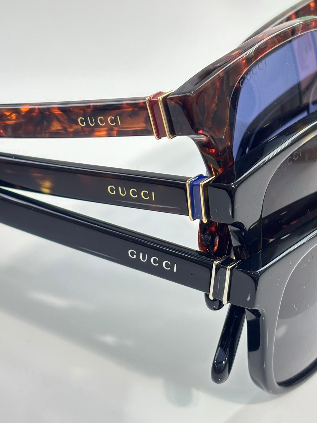 Gucci sunglasses close-up, tortoiseshell temples and gold-tone Gucci lettering