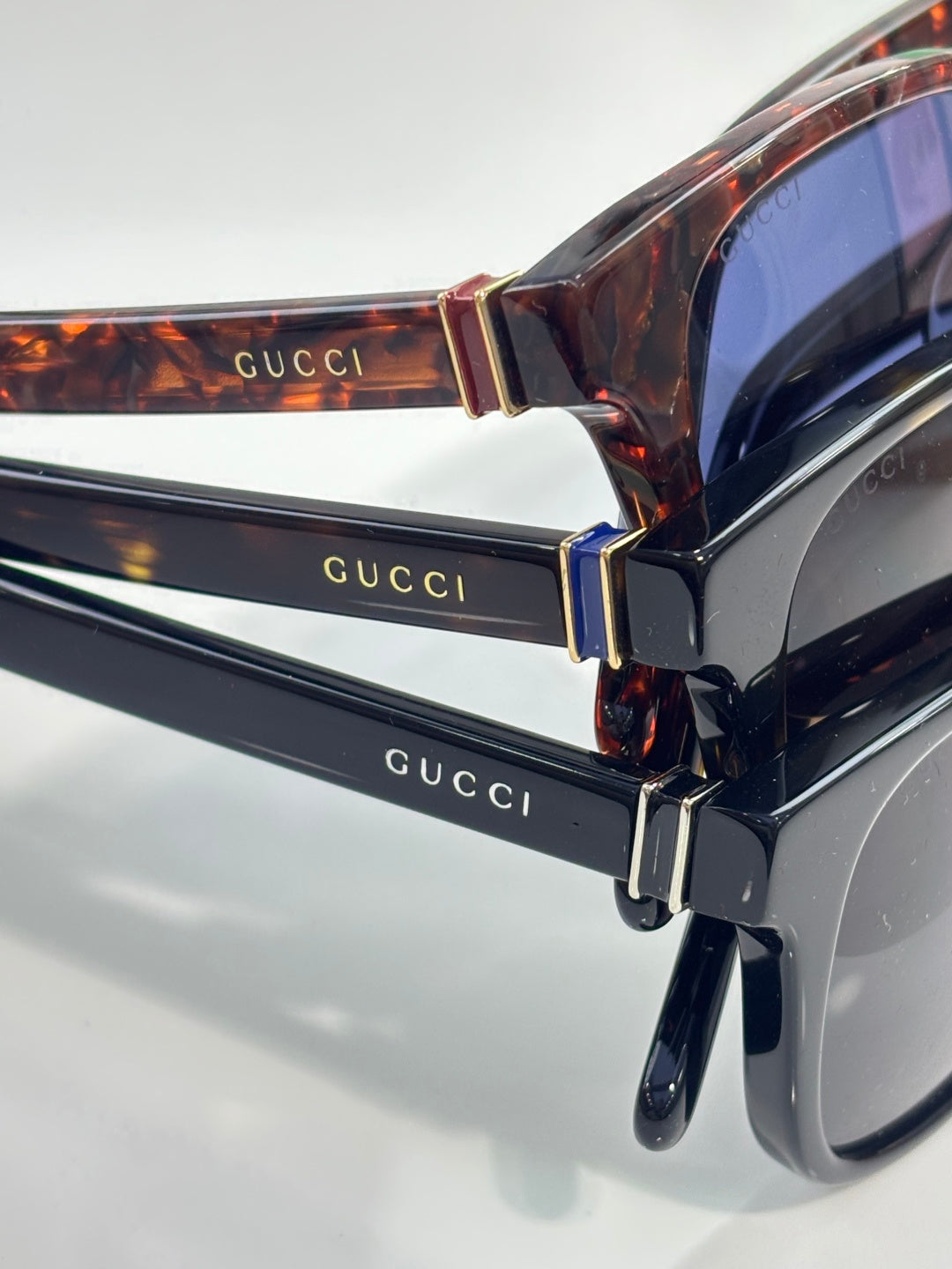 Gucci sunglasses close-up, tortoiseshell temples and gold-tone Gucci lettering