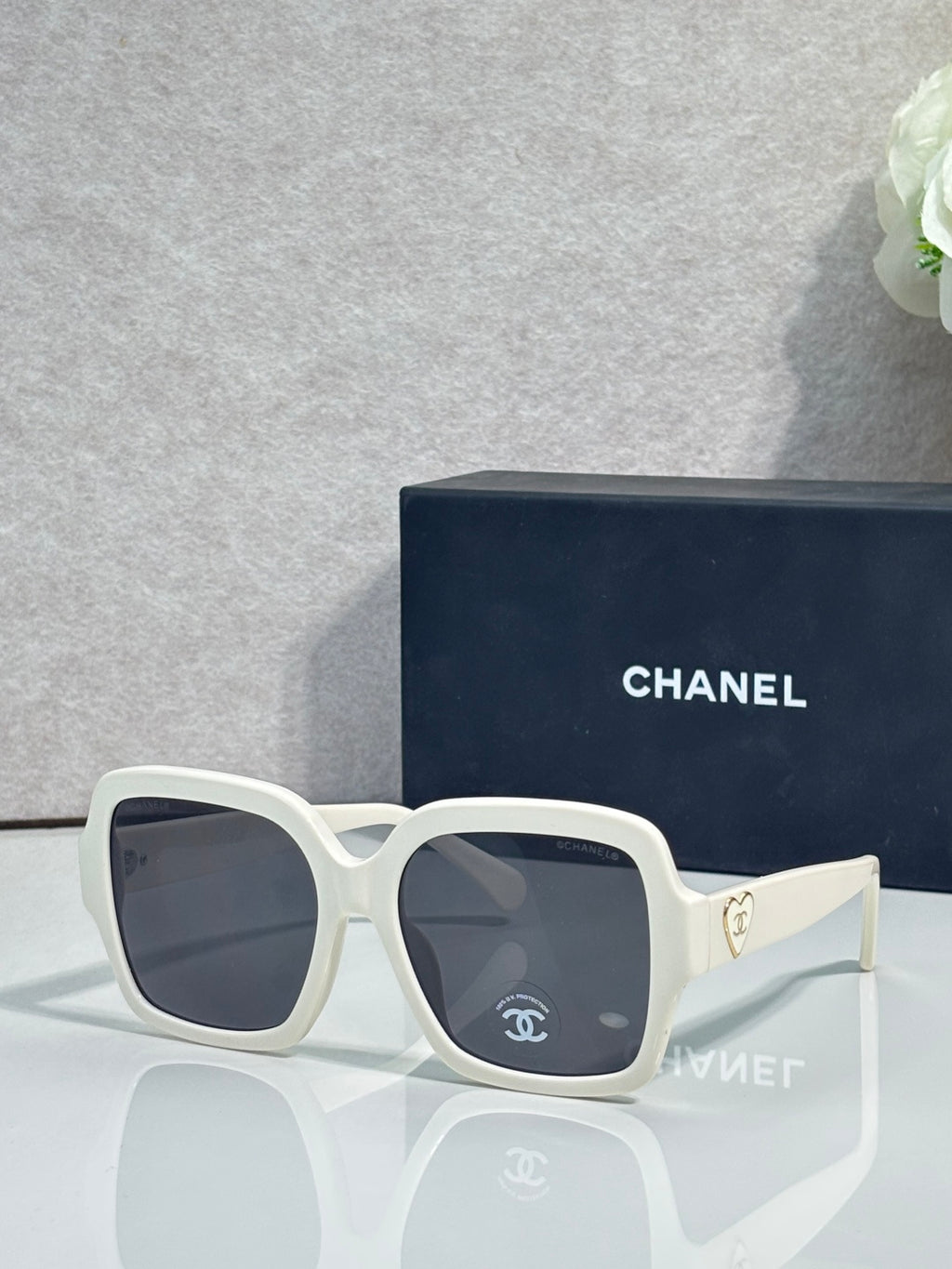 Square acetate sunglasses, white frame with dark lenses and Chanel logo