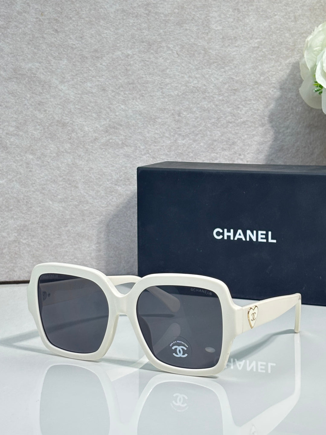 Square acetate sunglasses, white frame with dark lenses and Chanel logo