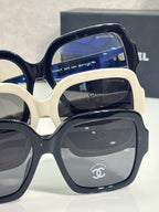 Stacked square acetate sunglasses, navy and white frames with dark lenses