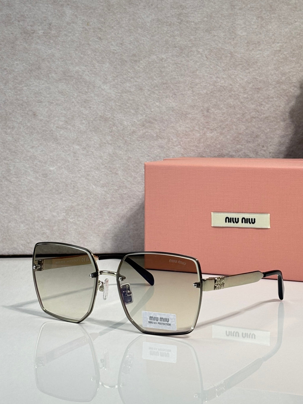 MiuMiu square glasses with olive-to-clear gradient lenses and silver-tone frame