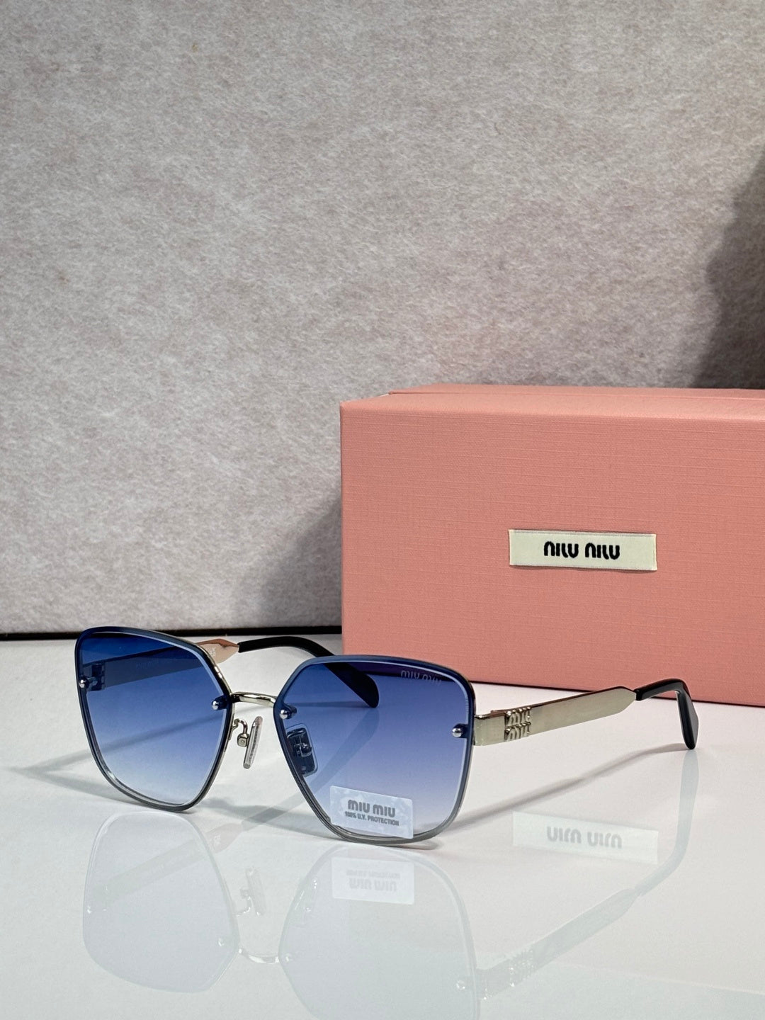 Sunglasses with dark blue lenses, black frame, and gold temple detailing
