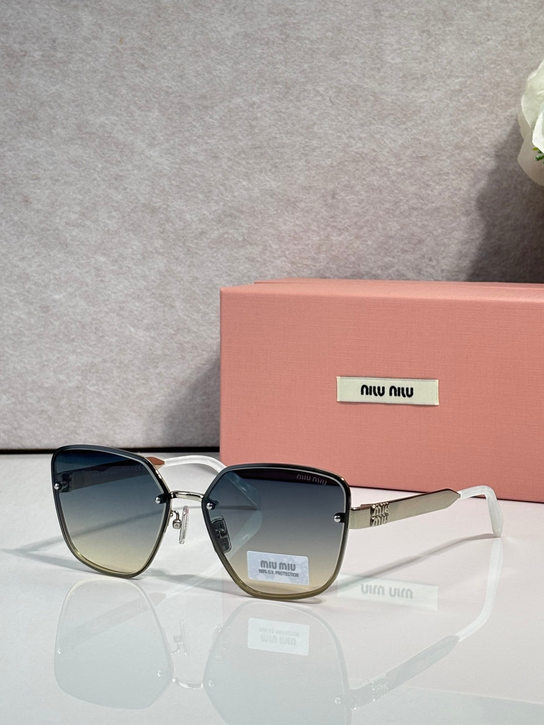 Sunglasses with teal-gray lenses, black frame, and gold temple hinge detail