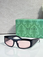 Dark blue cat-eye eyeglasses with pink lenses and gold-tone logo on arm