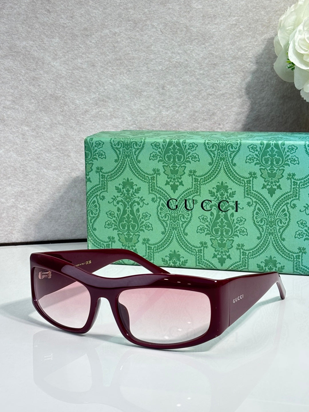 Dark blue cat-eye eyeglasses with burgundy lenses and white side logo accents