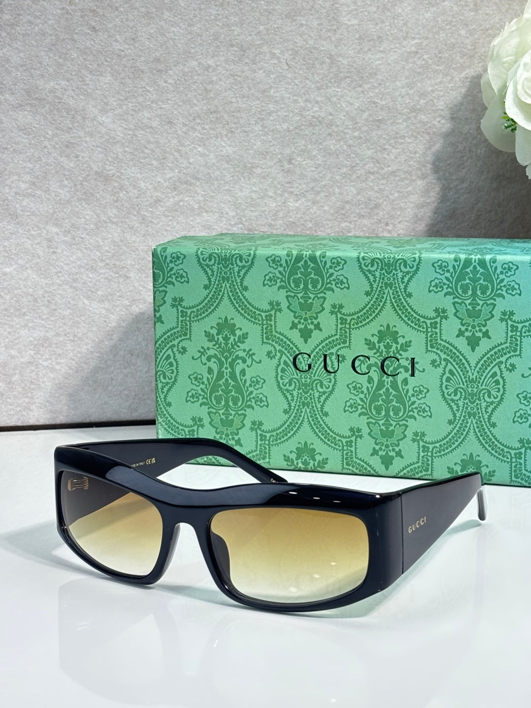 Dark blue cat-eye eyeglasses with pale yellow lenses and gold-tone logo on temple