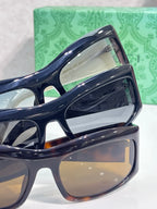 Dark blue cat-eye eyeglasses close-up with reflective lenses and white temple logo