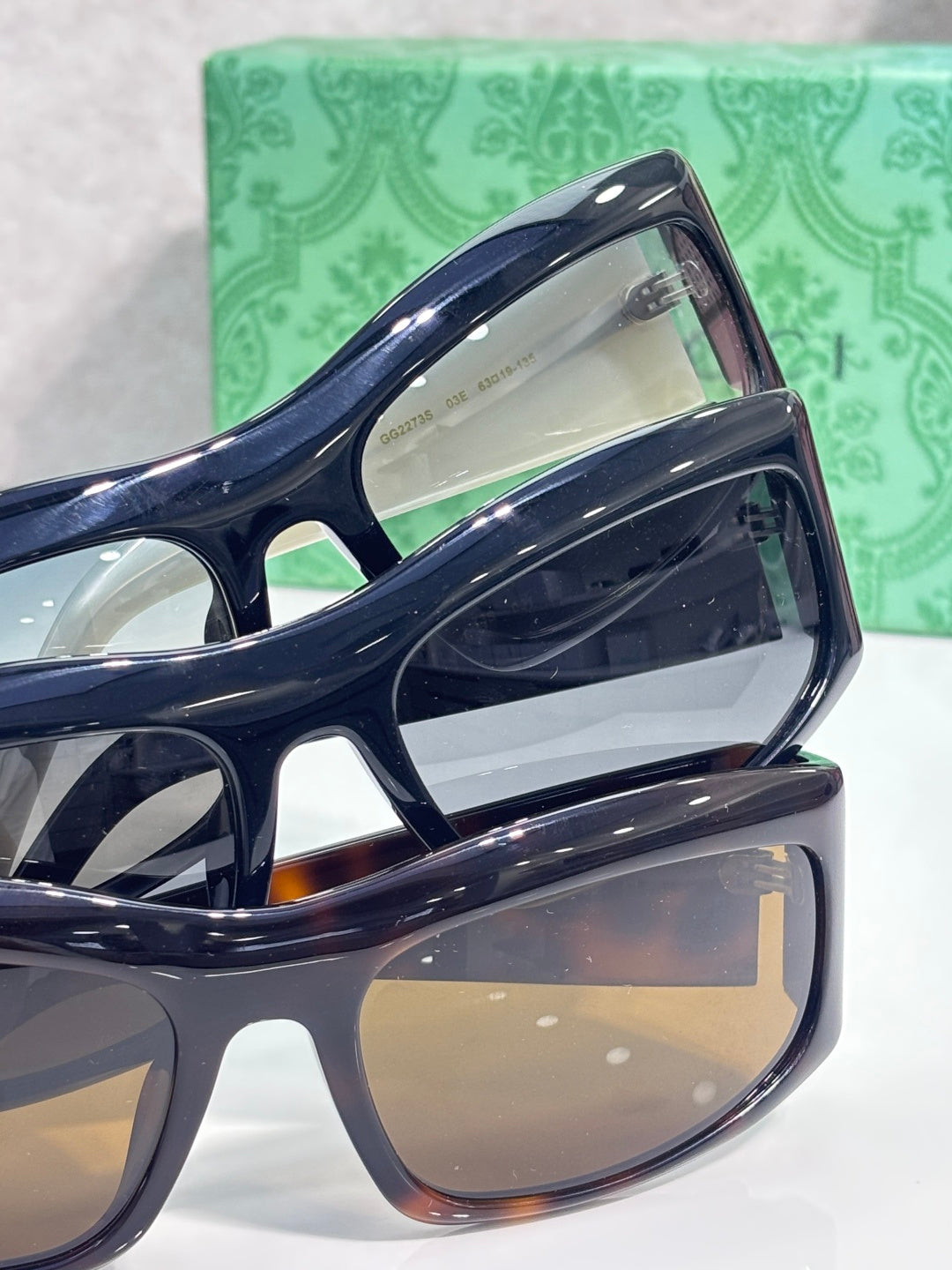 Dark blue cat-eye eyeglasses close-up with reflective lenses and white temple logo