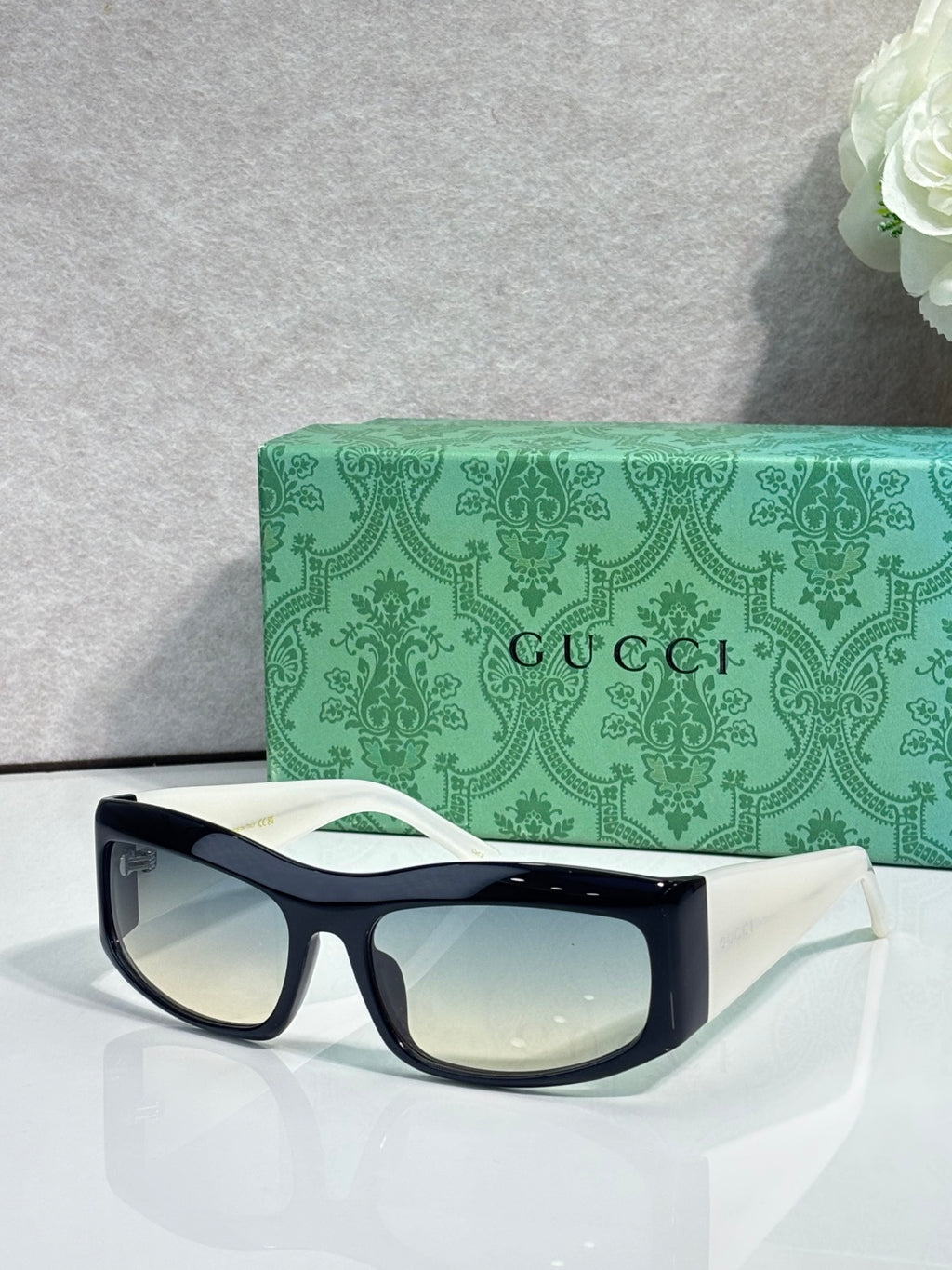 Black cat-eye eyeglasses with light lenses and small gold-tone logo at temple