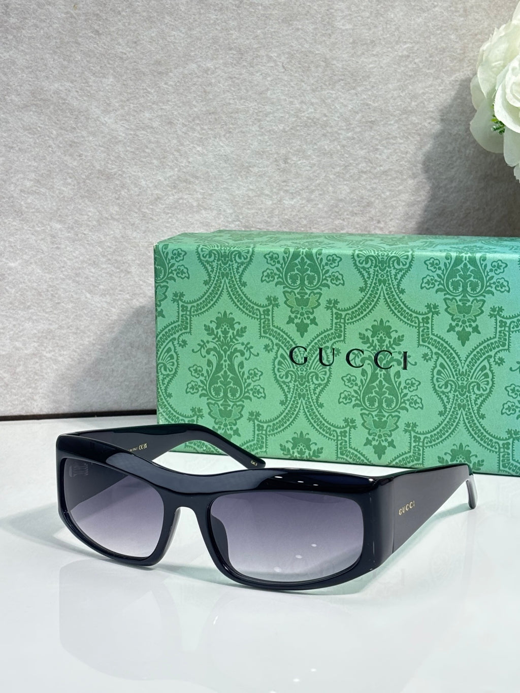 Dark blue cat-eye eyeglasses with gray lenses and small gold-tone logo on arm