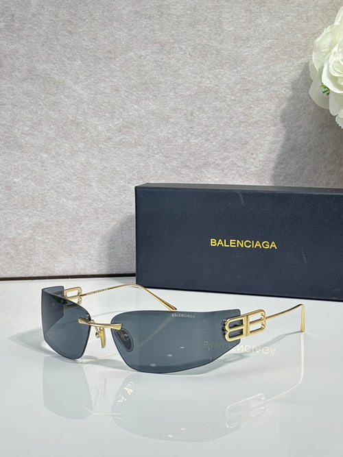 Balenciaga sunglasses with dark blue gradient lenses and gold-tone frame, bold logo arms