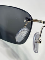 Balenciaga sunglasses close-up of black lens with metal hinge and logo temple piece