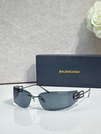 Balenciaga sunglasses with dark blue gradient lenses and black frame, gold logo accents
