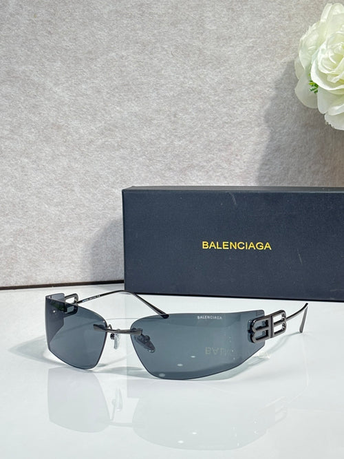 Balenciaga sunglasses with dark blue gradient lenses and black frame, gold logo accents