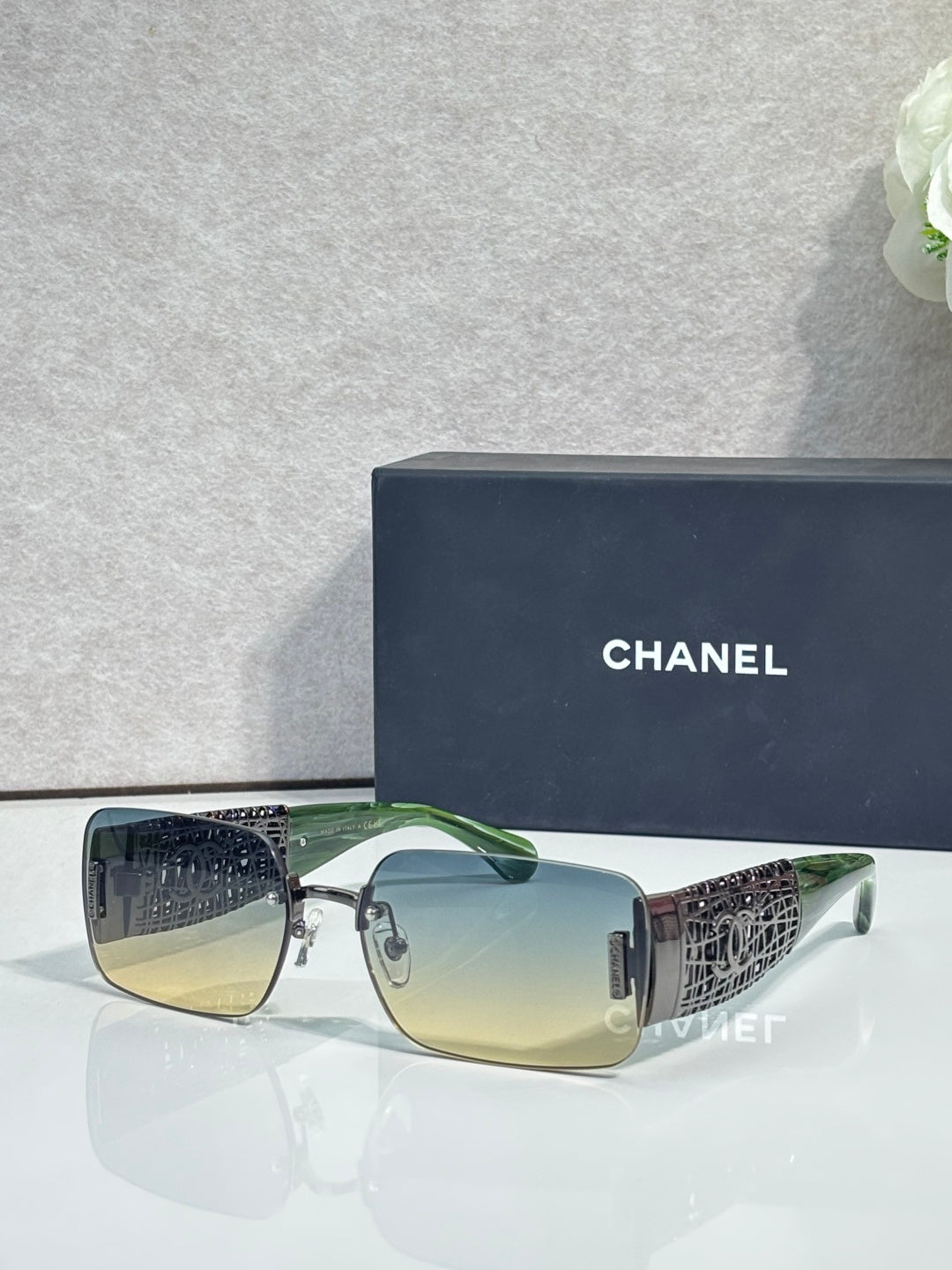 Chanel sunglasses with green lenses, dark frame, gold side detailing