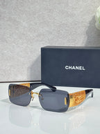 Chanel sunglasses with navy lenses, gold-tone frame, orange textured temple arms