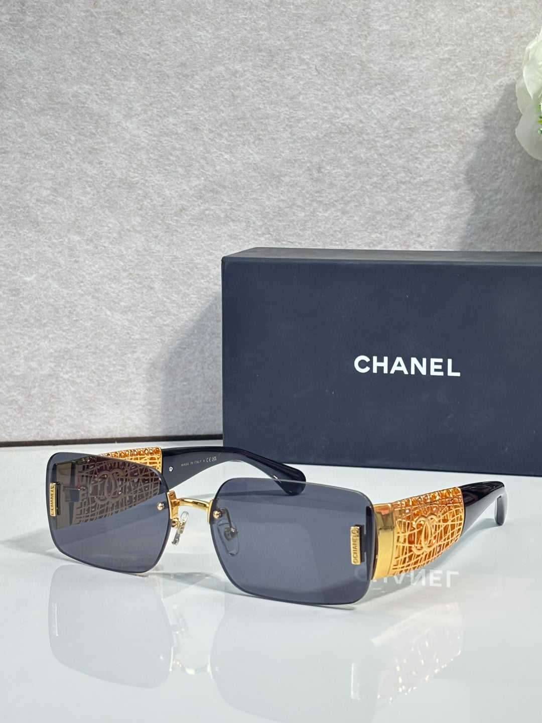 Chanel sunglasses with navy lenses, gold-tone frame, orange textured temple arms