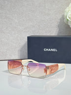 Chanel sunglasses with pink lenses, rose-gold frame, orange patterned temple tips