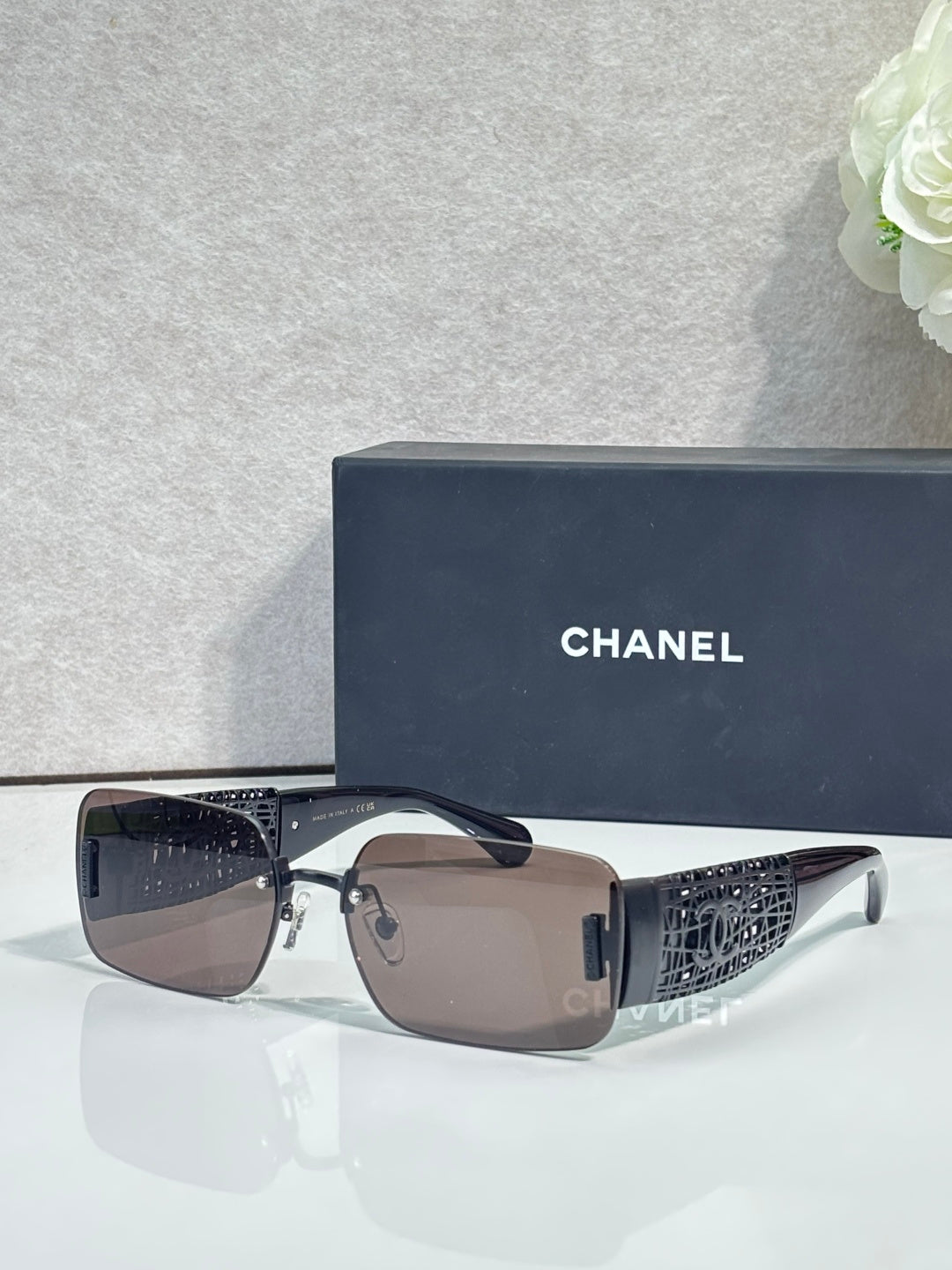 Chanel sunglasses with brown lenses, silver frame, black patterned temple arms