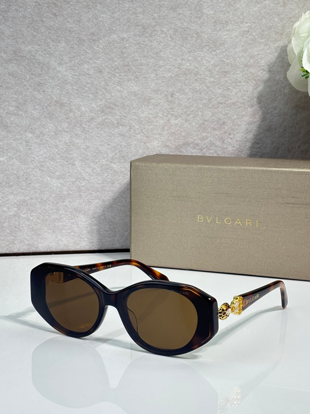 Bvlgari sunglasses with dark lenses and black round frames, tortoiseshell temple arms