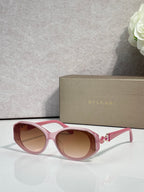 Bvlgari sunglasses with pink frames and brown-tinted round lenses, jeweled temple detail