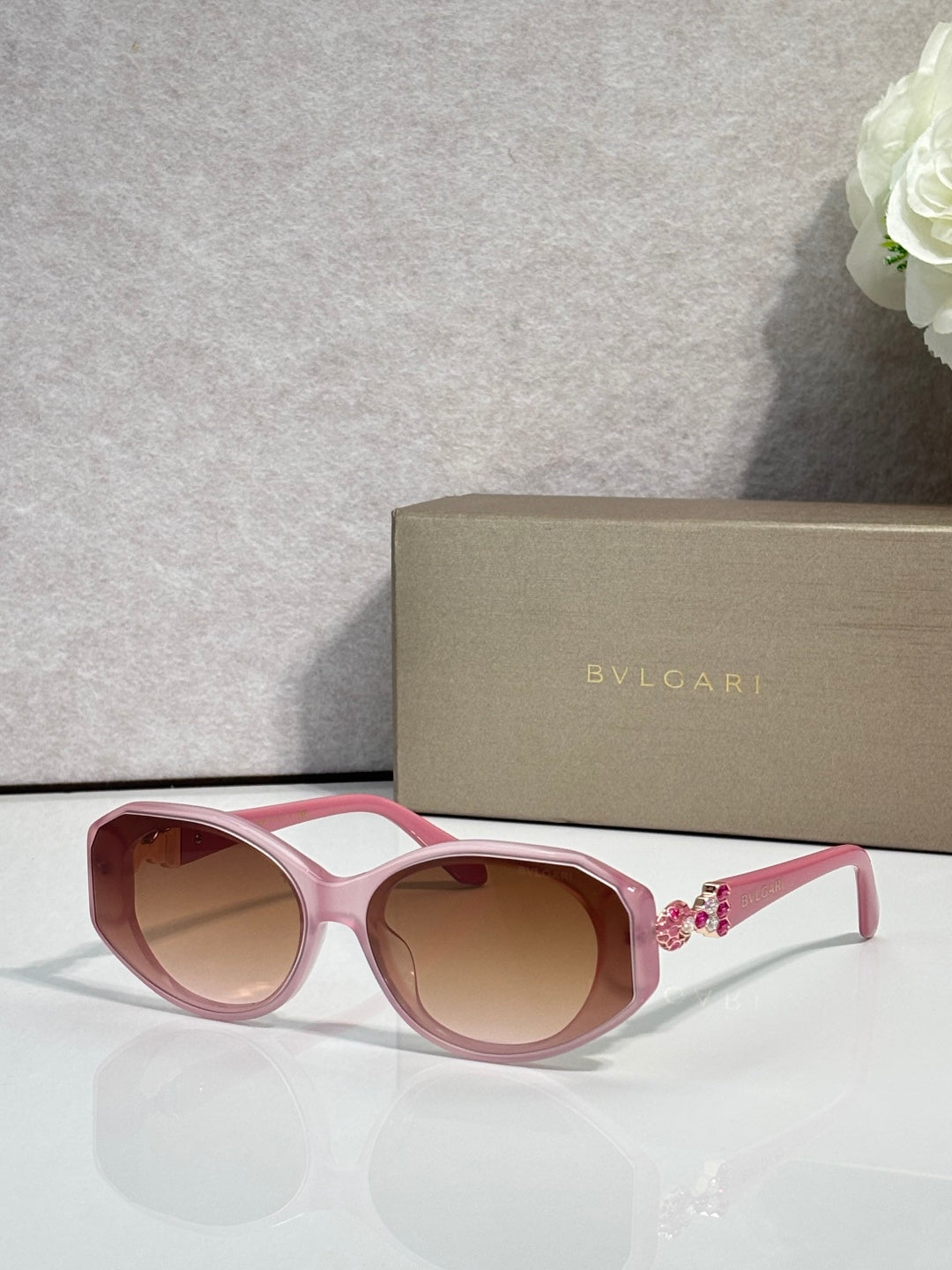 Bvlgari sunglasses with pink frames and brown-tinted round lenses, jeweled temple detail
