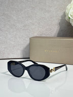 Bvlgari sunglasses with dark lenses, navy round frames, and light gray temple details