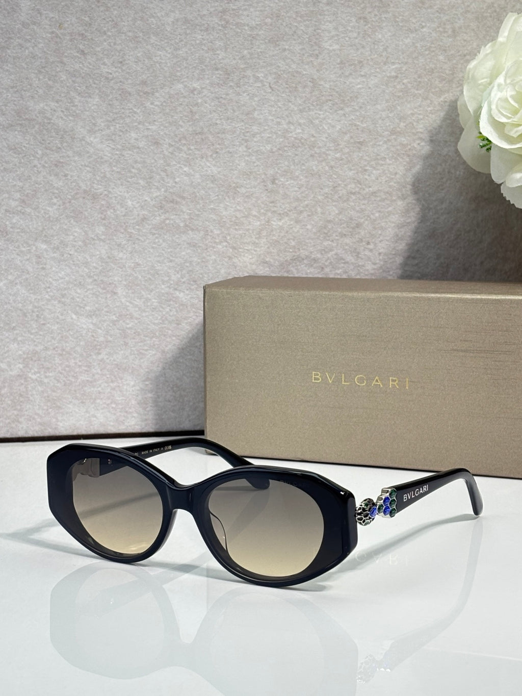 Bvlgari sunglasses with dark lenses and navy round frames, clear temple accents