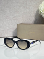 Bvlgari sunglasses with dark lenses and navy round frames, clear temple accents