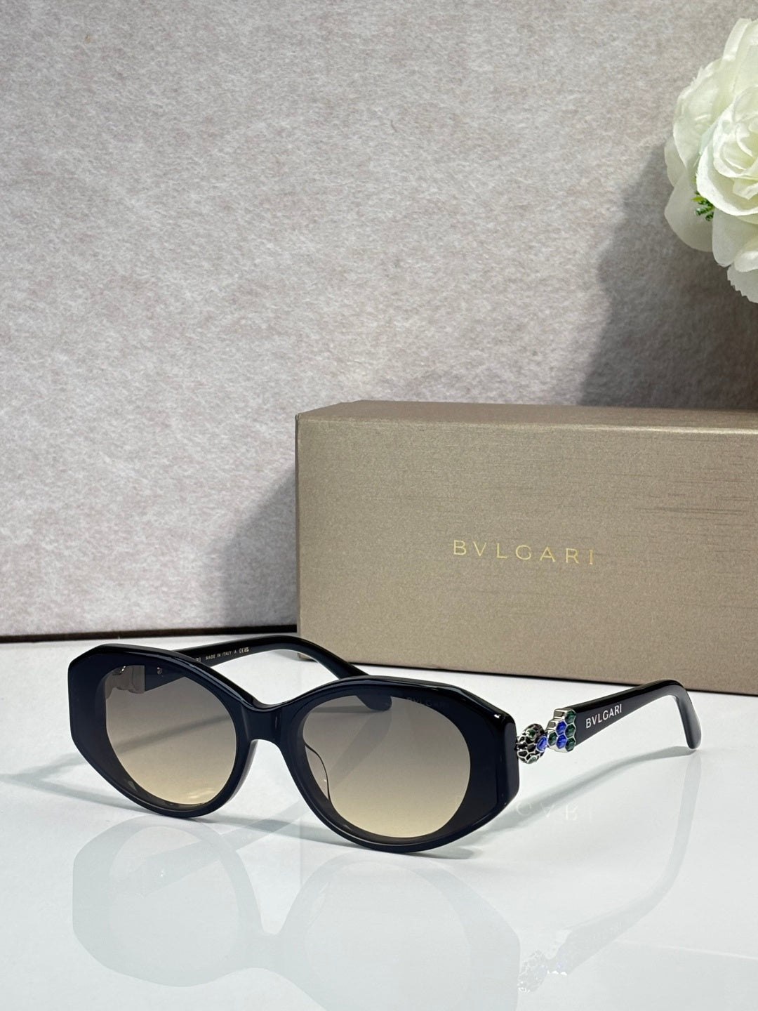 Bvlgari sunglasses with dark lenses and navy round frames, clear temple accents