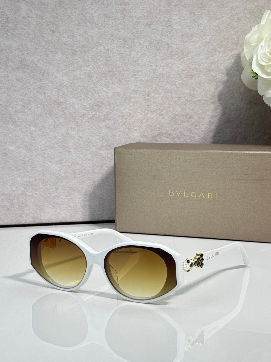Bvlgari sunglasses with white frames and yellow-tinted round lenses, jeweled temple detail