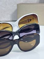 Bvlgari sunglasses close-up with white frame and dark blue lens, gold Bvlgari branding