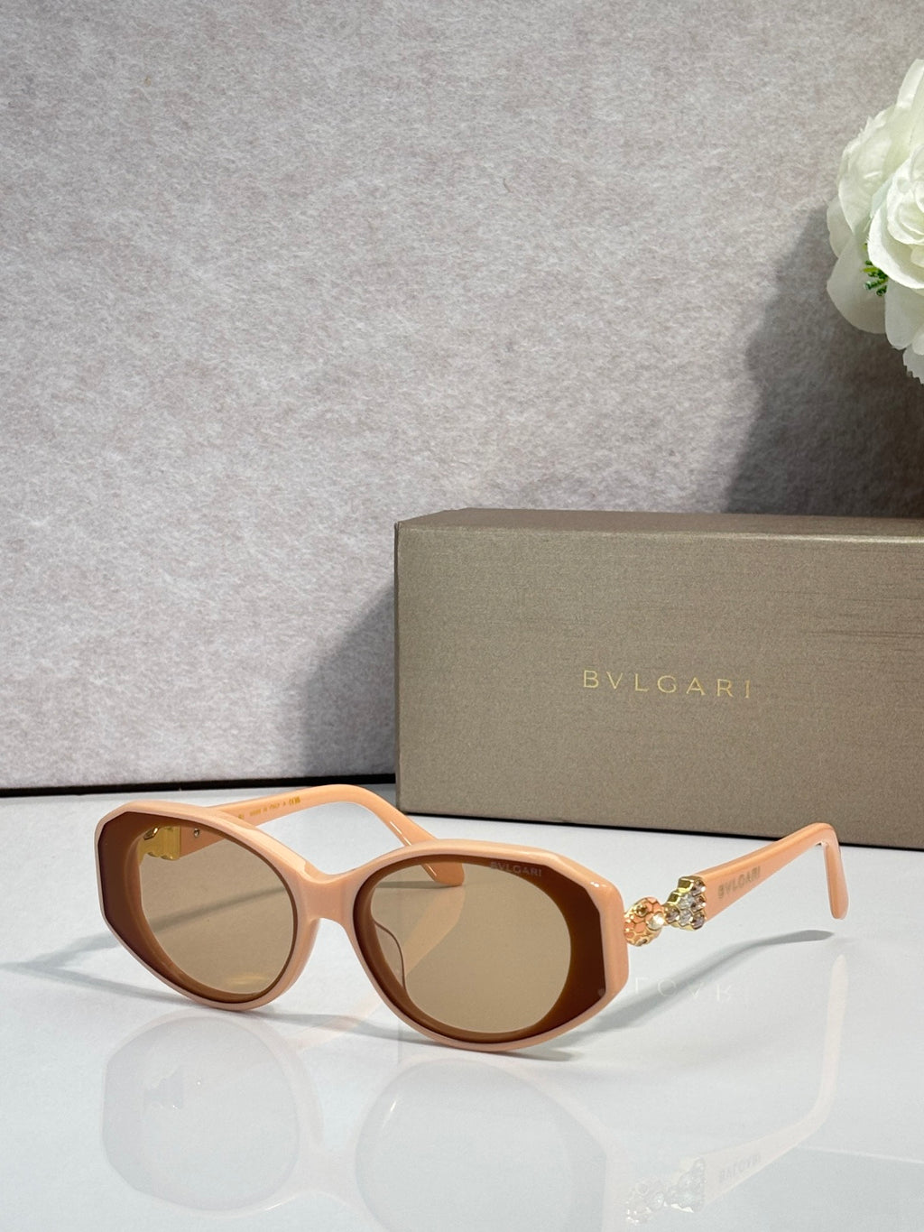 Bvlgari sunglasses with orange-brown frames and amber-tinted round lenses, gold temple emblem