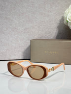 Bvlgari sunglasses with orange-brown frames and amber-tinted round lenses, gold temple emblem