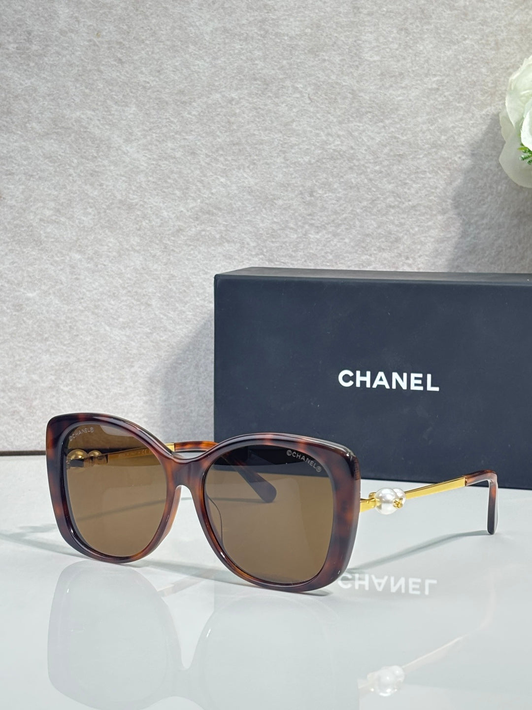 Chanel glasses with tortoiseshell square frames, tinted brown lenses, gold-tone temples