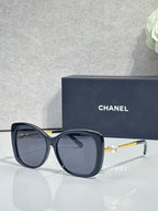 Chanel glasses with dark blue rounded frames, blue-tinted lenses, gold-tone temples