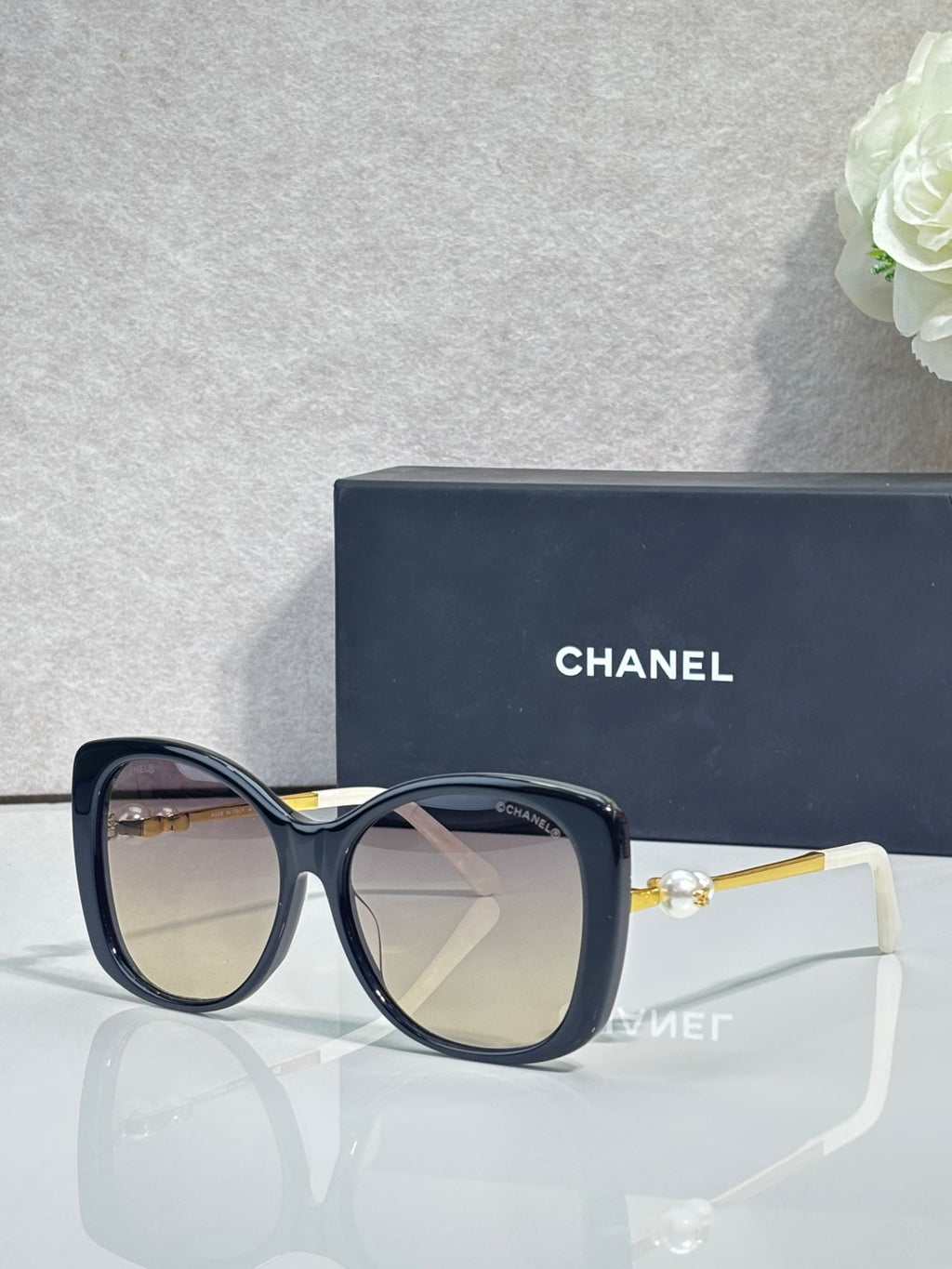 Chanel glasses with dark blue square frames, tinted clear lenses, gold-tone temples