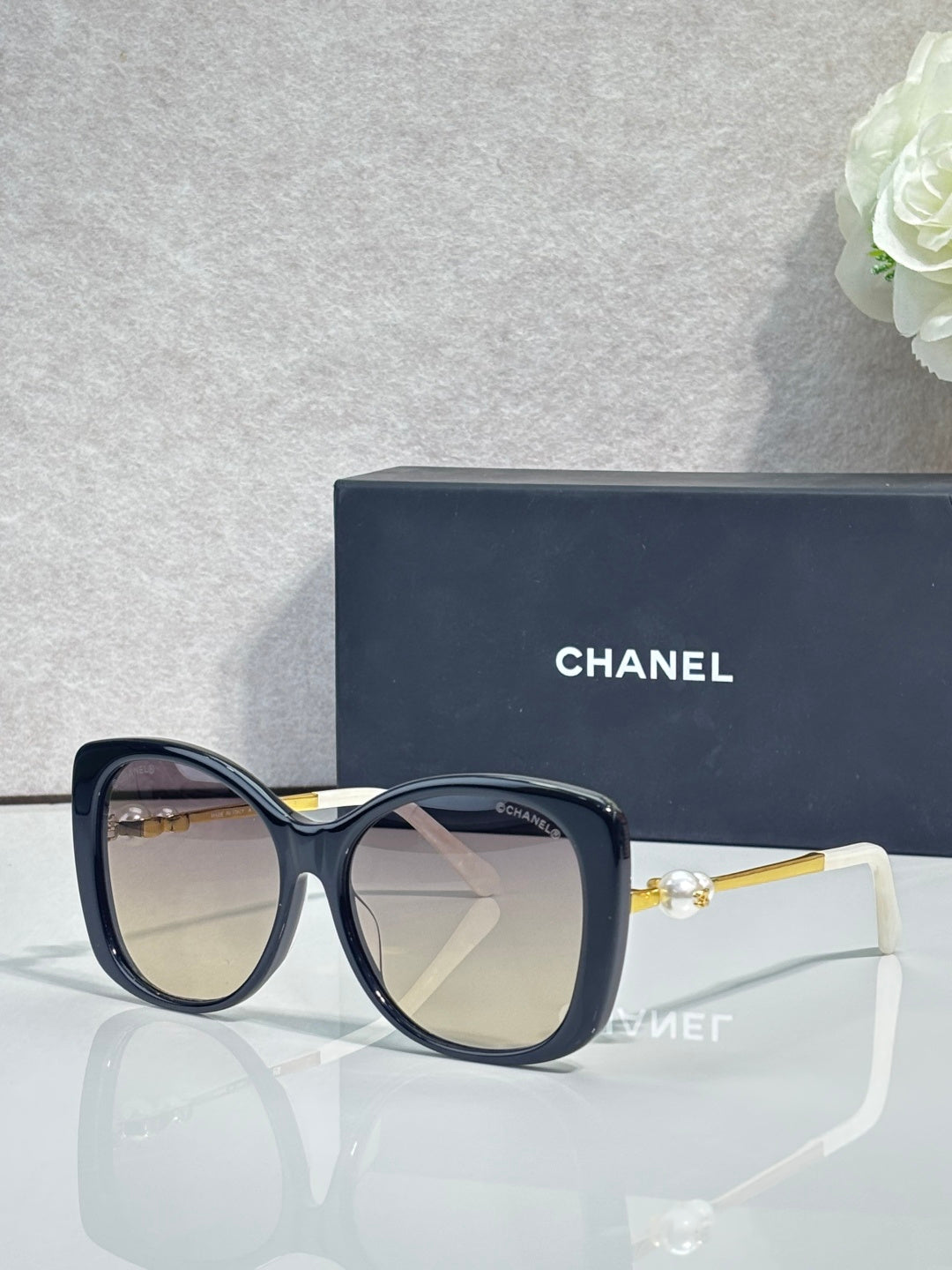 Chanel glasses with dark blue square frames, tinted clear lenses, gold-tone temples