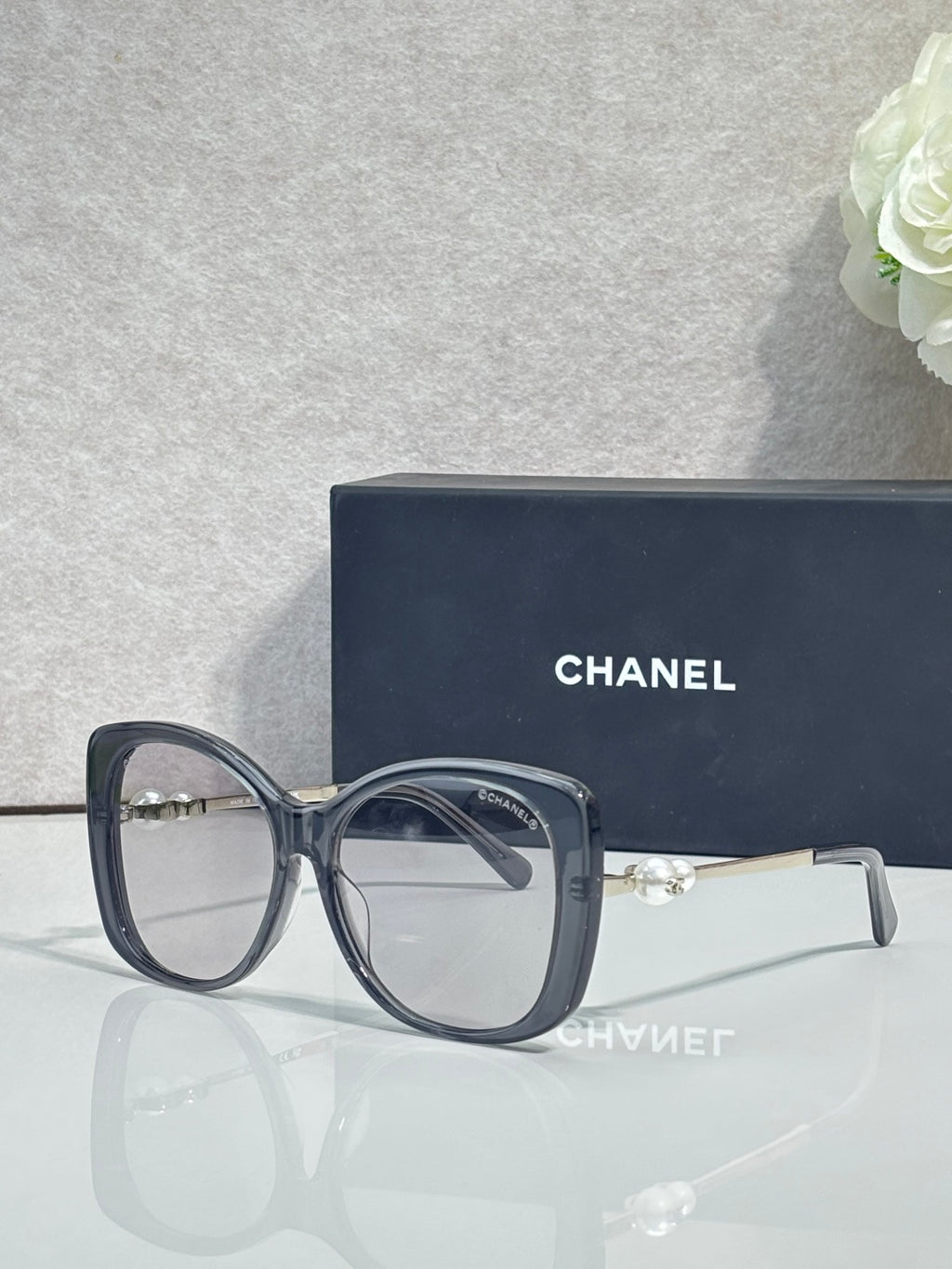 Chanel glasses with dark blue square frames, clear lenses, gold-tone temples