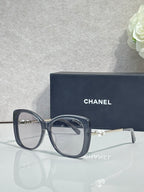 Chanel glasses with dark blue square frames, clear lenses, gold-tone temples