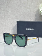 Chanel glasses with dark blue frames, green-tinted lenses, gold-tone temples