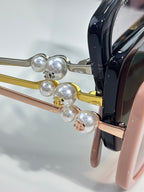 Chanel glasses detail with pearl-like ornaments and gold-tone metal temples