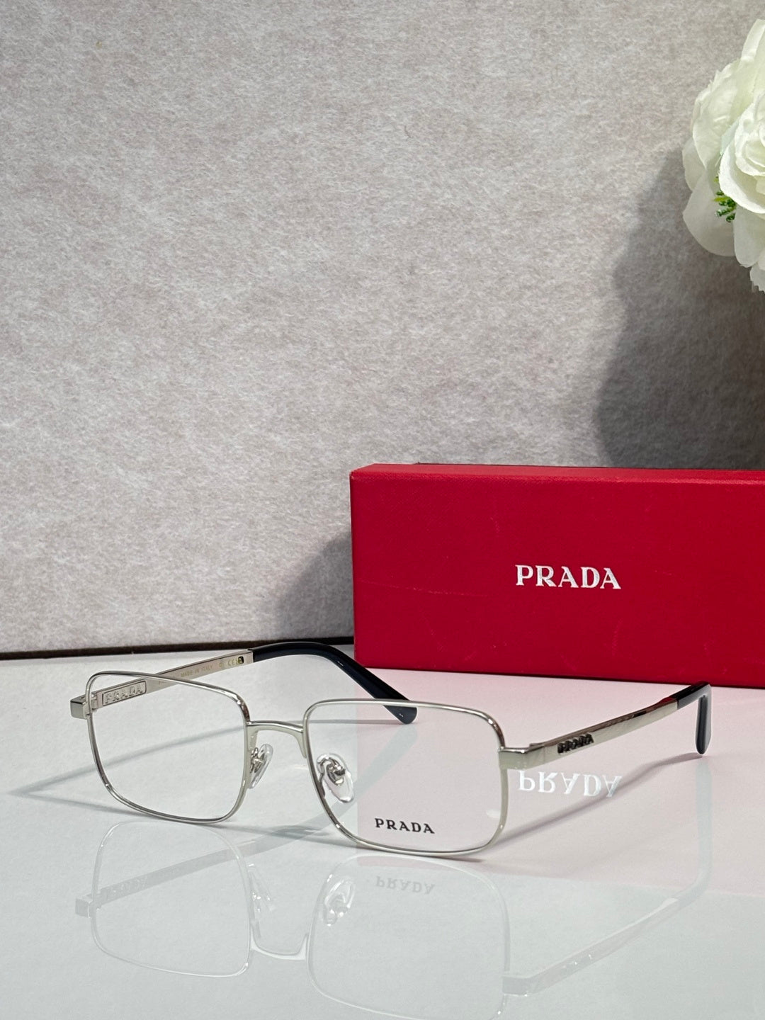 Prada rectangular eyeglasses with black frame and clear lenses, angled view.