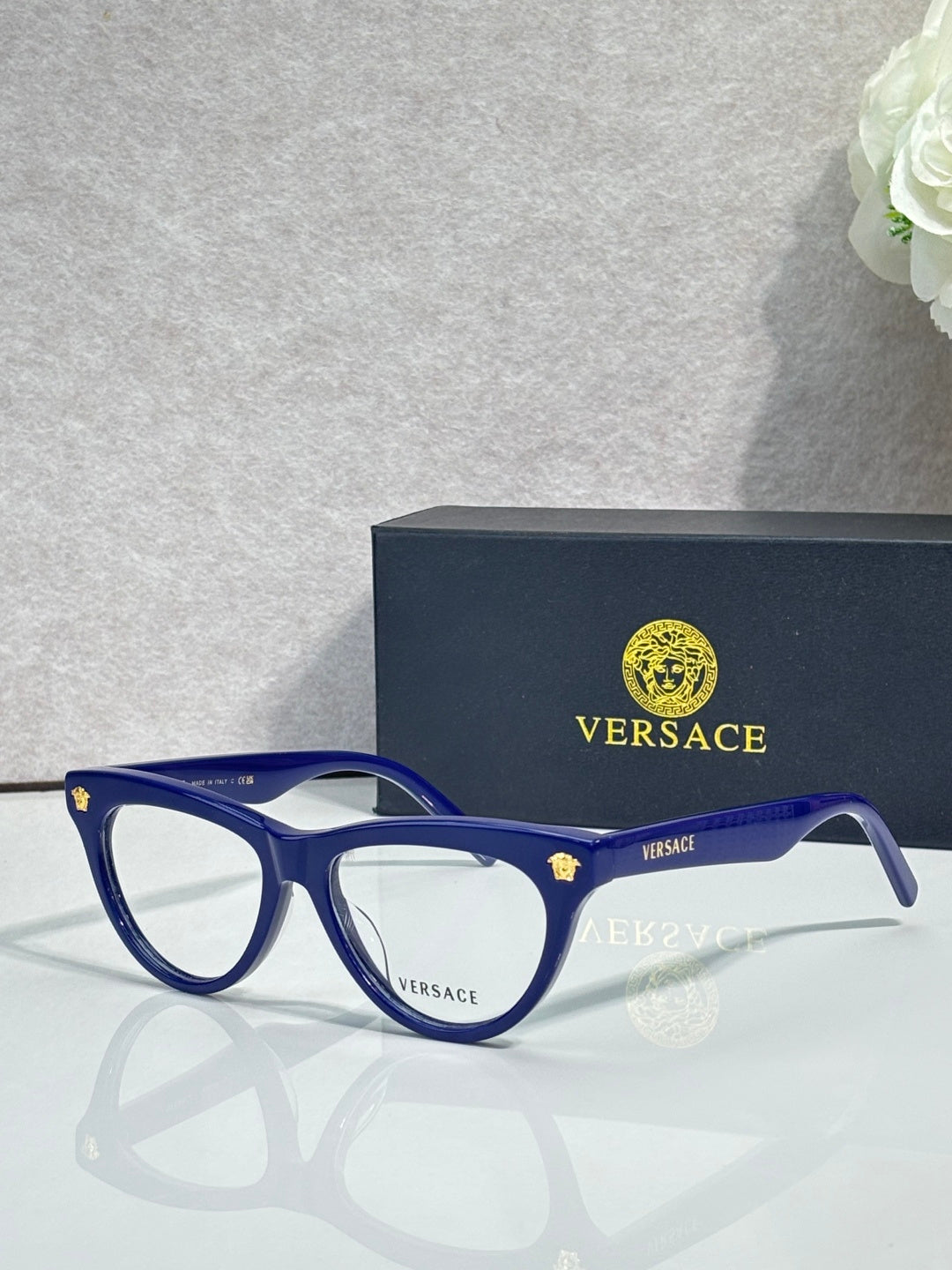 Versace optical glasses, royal blue frame with gold logo accents, clear lenses.