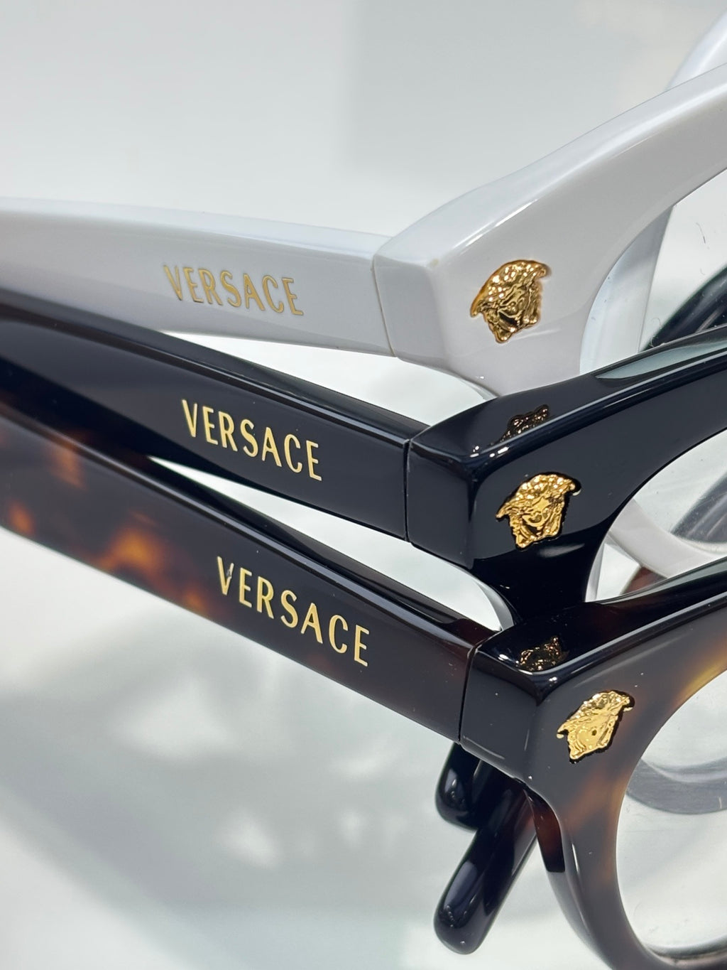 Versace optical glasses, black temples with gold Medusa emblem and branding.