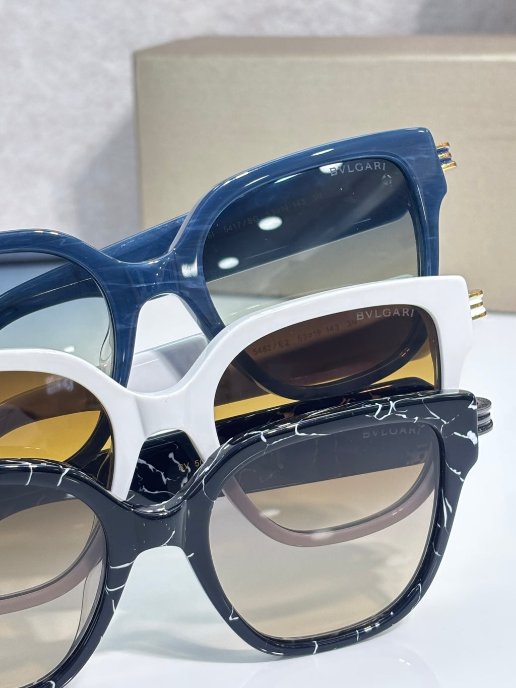 White and blue square sunglasses with tinted lenses and gold-tone temple details